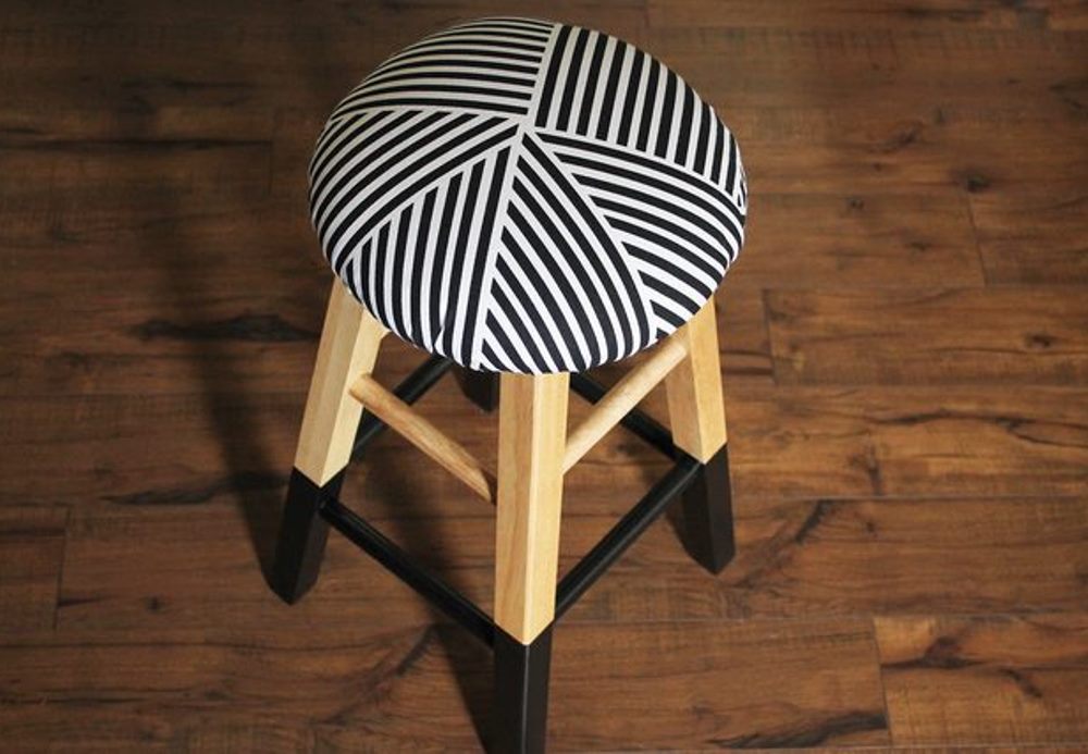 Tabouret en bois retapissé avec un tissu geometrique noir et blanc