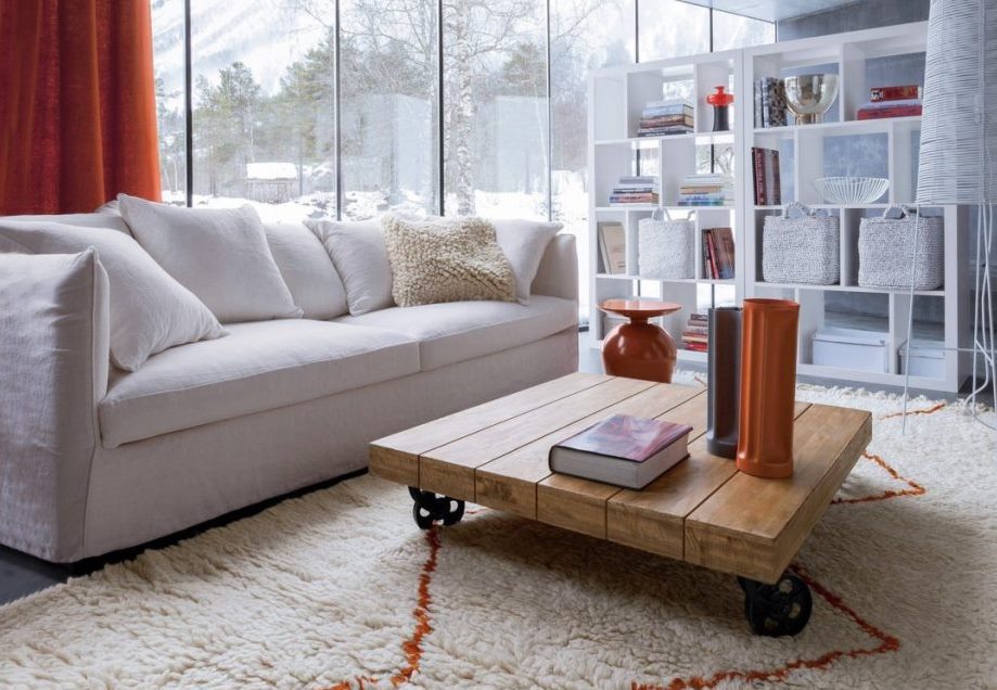 Salon avec canapé blanc, tapis beige et rideaux épais orange