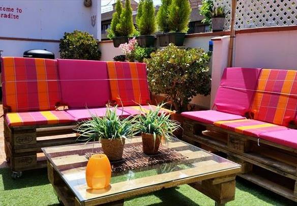 Salon de jardin lounge avec des palettes et coussins colorés